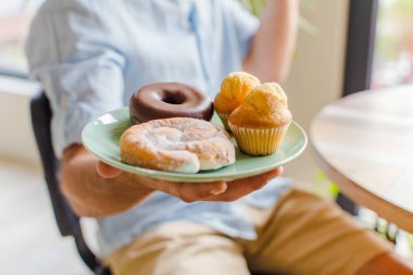Genç adam kahvaltısını evde yapıyor.