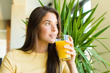 Genç ve güzel bir kadın kahvaltısını evde yapıyor.