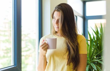 Genç ve güzel bir kadın kahvaltısını evde yapıyor.