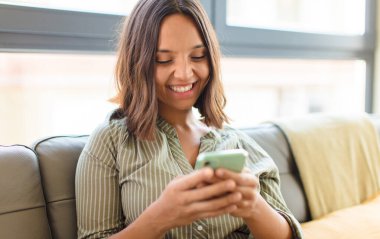 Genç ve güzel bir kadın cep telefonunu kullanıyor.