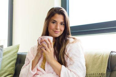 Genç ve güzel bir kadın kahvaltısını evde yapıyor.