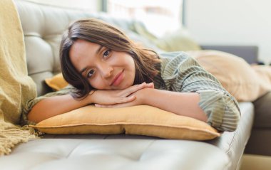 Genç ve güzel bir kadın evde dinleniyor.