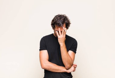 Genç sakallı adam sigara içiyor.