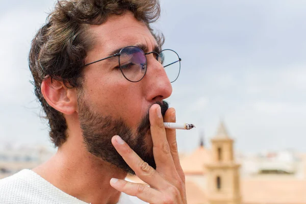 年轻的留胡子男子抽烟 — 图库照片