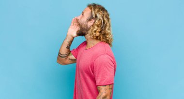 Sarışın adam profili, mutlu ve heyecanlı görünüyor, bağırıyor ve kenardaki boşluğu kopyalamak için arıyor.