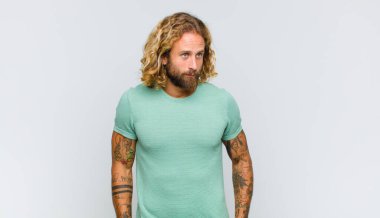 Endişeli, stresli, endişeli ve korkmuş, panikleyen ve dişlerini sıkan sarışın bir adam.