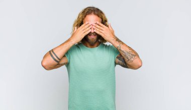 Sarışın adam gülümsüyor ve mutlu hissediyor, iki eliyle gözlerini kapatıyor ve inanılmaz bir sürpriz bekliyor.