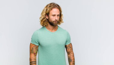 Sarışın adam üzgün, üzgün ya da kızgın ve olumsuz bir tavır takınıyor, anlaşmazlık içinde kaşlarını çatıyor.