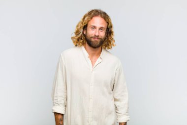 Sarışın adam neşeli, neşeli, mutlu, kendinden emin ve rahat bir ifadeyle gülümsüyor.