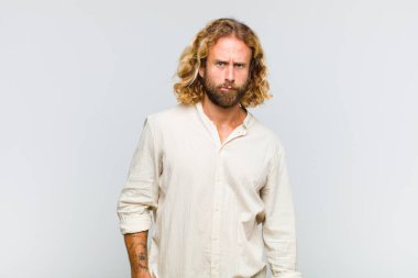 Sarışın adam kendini cahil, kafası karışmış ve hangi seçeneği seçeceğine karar verememiş, sorunu çözmeye çalışıyor.