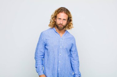 blonde man feeling puzzled and confused, with a dumb, stunned expression looking at something unexpected