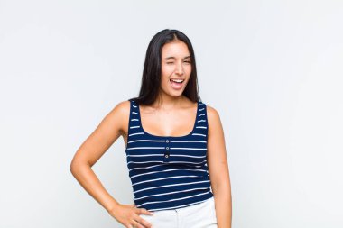 Genç bayan mutlu ve arkadaş canlısı görünüyor, gülümsüyor ve sana olumlu bir tavırla göz kırpıyor.