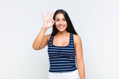 Genç bir kadın kendini başarılı ve tatmin olmuş hissediyor, ağzı açık gülümsüyor, elle işaret veriyor.