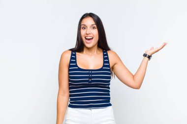 Genç bir kadın mutlu, şaşırmış ve neşeli, pozitif bir tavırla gülümsüyor, bir çözüm ya da fikri fark ediyor.