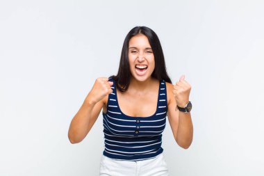 Genç bir kadın zaferle bağırıyor, gülüyor, mutlu ve heyecanlı hissediyor.