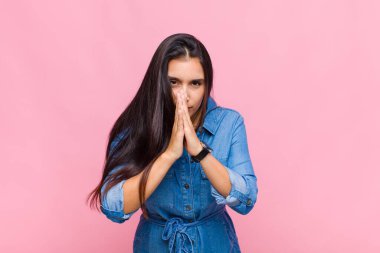 Genç bir kadın endişeli, umutlu ve dindar, sadık bir şekilde avuç içiyle dua ediyor, af diliyor.