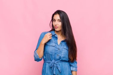 Genç kadın kibirli, başarılı, pozitif ve gururlu görünüyor, kendini gösteriyor.