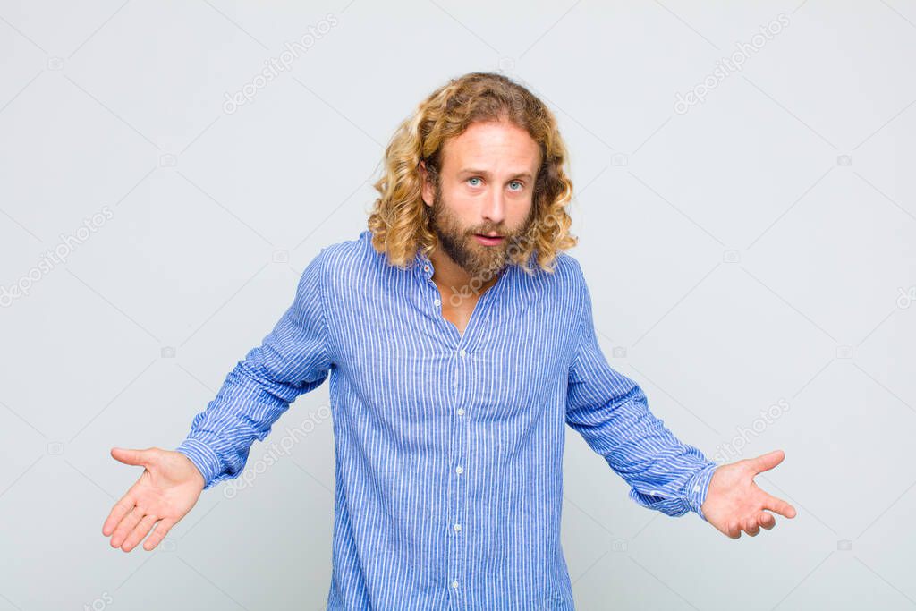 blonde man feeling clueless and confused, having no idea, absolutely puzzled with a dumb or foolish look