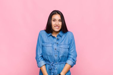 Genç bir kadın şaşkın ve şaşkın görünüyor. Sinirli bir hareketle dudağını ısırıyor. Sorunun cevabını bilmiyor.