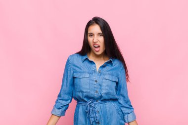 young woman feeling puzzled and confused, with a dumb, stunned expression looking at something unexpected