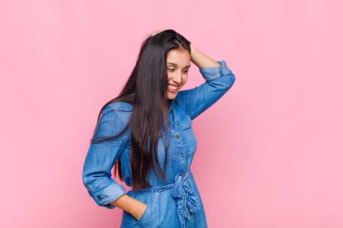 Genç bayan neşeli ve sıradan bir şekilde gülümsüyor, olumlu, mutlu ve kendinden emin bir bakışla göğüs göğüse tutuşuyor.