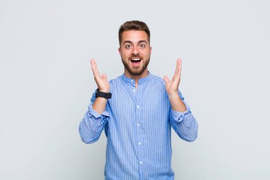 Genç adam mutlu, heyecanlı, şaşırmış ya da şaşırmış hissediyor. İnanılmaz bir şeye gülümsüyor ve şaşırıyor.