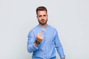 Genç adam kızgın, sinirli, asi ve agresif hissediyor, orta parmağını hareket ettiriyor, karşı koyuyor.