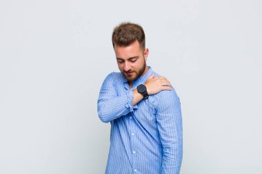 Genç adam yorgun, stresli, endişeli, hayal kırıklığına uğramış ve depresyonda, sırtı ya da boynu ağrıyan