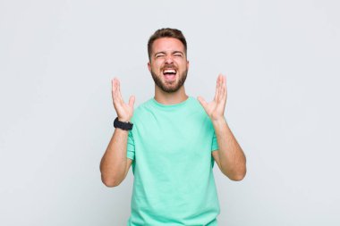 Genç adam öfkeyle bağırıyor, stresli hissediyor ve ellerini havaya kaldırıp neden ben diye bağırıyor.