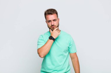 Genç adam ciddi görünüyor, kafası karışık, kararsız ve düşünceli, seçenekler ve seçimler arasında şüpheci.