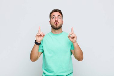 Delikanlı korkuyla ve ağzı açık bir şekilde şaşkın ve şaşkın bir bakışla yukarıya bakıyor.