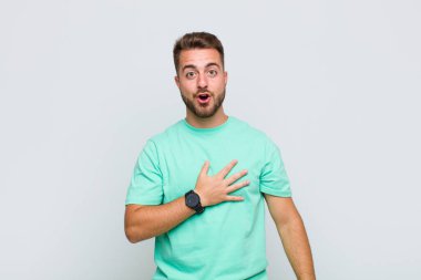 Genç adam şok olmuş ve şaşırmış hissediyor, gülümsüyor, el ele tutuşuyor, o olmaktan ya da minnettarlık göstermekten mutlu.