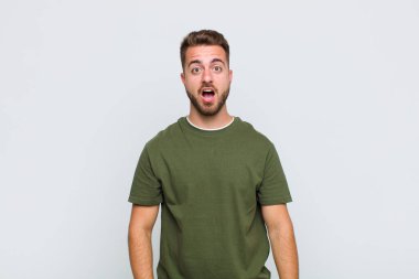 Genç adam şok olmuş ya da şaşırmış görünüyor, ağzı açık bir şekilde 