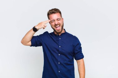 Genç adam mutsuz ve stresli görünüyor, intihar jesti elle silah işareti yapıyor, kafasını işaret ediyor.