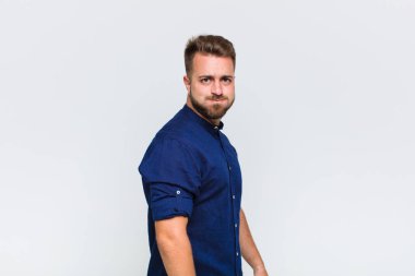 Genç adam şapşal, çılgın, şaşırmış bir ifadeyle, yanakları şişmiş, doldurulmuş, şişman ve yemekle dolu