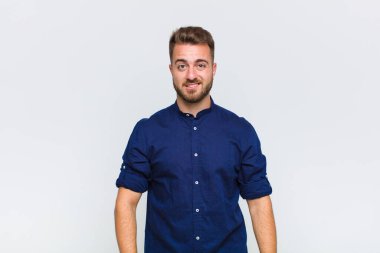 Genç adam şaşkın ve şaşkın görünüyor, gergin bir hareketle dudağını ısırıyor, sorunun cevabını bilmiyor.