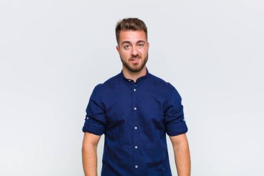 young man feeling puzzled and confused, with a dumb, stunned expression looking at something unexpected