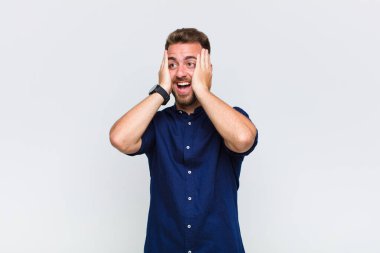 Genç adam mutlu, heyecanlı ve şaşırmış hissediyor, iki eli yüzü yana bakıyor.