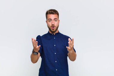 Genç adam son derece şok olmuş ve şaşırmış, endişeli ve paniklemiş hissediyor, stresli ve dehşete kapılmış bir bakışla