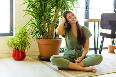 Güzel bir kadın neşeli ve sıradan bir şekilde gülümsüyor, olumlu, mutlu ve kendinden emin bir bakışla yumruk yumruğa.