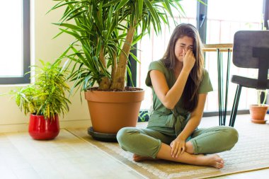 Güzel bir kadın iğreniyor, kötü ve nahoş bir koku duymamak için burnunu tutuyor.