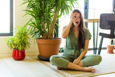 Güzel bir kadın şaşkın, şaşırmış ve şaşırmış hissediyor, elinde şaşkın, inançsız bir bakışla gözlük tutuyor.