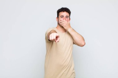 Genç adam sana gülüyor, kamerayı işaret ediyor ve seninle dalga geçiyor ya da alay ediyor.