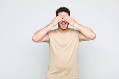 Genç adam gülümsüyor ve mutlu hissediyor, iki eliyle gözlerini kapatıyor ve inanılmaz bir sürpriz bekliyor.