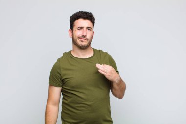 Genç adam kibirli, başarılı, pozitif ve gururlu görünüyor.