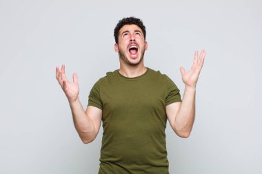 Genç adam öfkeyle bağırıyor, stresli hissediyor ve ellerini havaya kaldırıp neden ben diye bağırıyor.