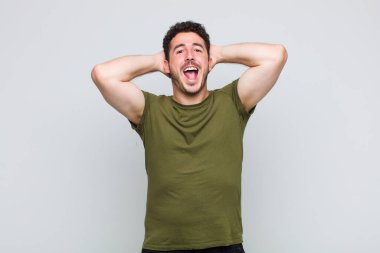 Genç adam mutlu, kaygısız, arkadaş canlısı ve rahat görünüyor. Hayattan ve başarıdan keyif alıyor, olumlu bir tavırla.