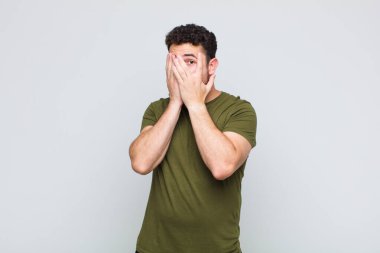 Delikanlı korkmuş ya da utanmış hissediyor. Gözleri yarı kapalı ya da ellerle dikizliyor ya da dikizliyor.