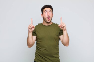 Delikanlı korkuyla ve ağzı açık bir şekilde şaşkın ve şaşkın bir bakışla yukarıya bakıyor.