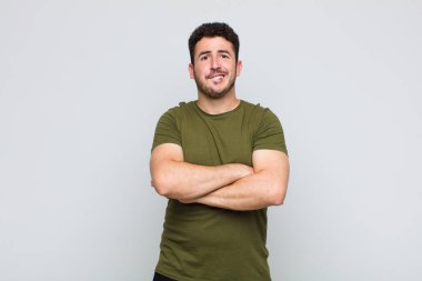 Genç adam şaşkın ve şaşkın görünüyor, gergin bir hareketle dudağını ısırıyor, sorunun cevabını bilmiyor.